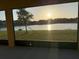 Screened-in patio provides serene views of the pond and surrounding landscape at sunset at 19514 Sea Myrtle Way, Tampa, FL 33647