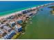 Breathtaking aerial view of waterfront condo complex near a white sand beach, with boat docks and lush surroundings at 19925 Gulf Blvd # 503, Indian Shores, FL 33785