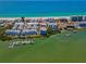 Aerial view of a condo building with dock access, situated near the beach and surrounded by lush landscaping at 19925 Gulf Blvd # 503, Indian Shores, FL 33785