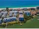 High-angle aerial view of waterfront condo complex with beach access and boat docks, perfect for coastal living at 19925 Gulf Blvd # 503, Indian Shores, FL 33785