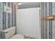 Bathroom with a toilet and a shower curtain featuring unique patterned wallpaper at 19925 Gulf Blvd # 503, Indian Shores, FL 33785
