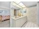 Bathroom featuring double vanity, a well-lit mirror, and a view of the adjacent bedroom at 19925 Gulf Blvd # 503, Indian Shores, FL 33785