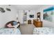 Bedroom featuring twin beds, dresser, TV, and access to the ensuite bathroom at 19925 Gulf Blvd # 503, Indian Shores, FL 33785