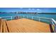 Waterfront property featuring a wooden dock with white railings and a hose, offering scenic water views at 19925 Gulf Blvd # 503, Indian Shores, FL 33785