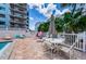 Poolside seating area with table, chairs, and shade umbrella at 19925 Gulf Blvd # 503, Indian Shores, FL 33785