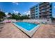 Community pool with lounge chairs and a bright blue apartment building at 19925 Gulf Blvd # 503, Indian Shores, FL 33785