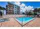 Community pool with lounge chairs surrounded by building and townhouses at 19925 Gulf Blvd # 503, Indian Shores, FL 33785