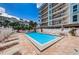 Community pool with lounge chairs, umbrellas, and a bright blue apartment building at 19925 Gulf Blvd # 503, Indian Shores, FL 33785