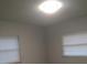 Bright bedroom featuring neutral walls, updated flooring, and natural light from two windows at 211 Harmony Ln, Brandon, FL 33511