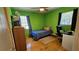 Bedroom with bright green walls, wood floors, desk, and bed by window at 2505 Minnehaha, Tampa, FL 33614