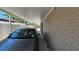A gray car is parked in a carport with brick columns offering shaded parking on a sunny day at 2505 Minnehaha, Tampa, FL 33614