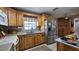 Well-lit kitchen boasts stainless steel refrigerator, ample counter space and wooden cabinetry at 2505 Minnehaha, Tampa, FL 33614