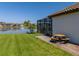 Relaxing backyard with view of the lake, a table and a screened in porch at 28857 Picana Ln, Wesley Chapel, FL 33543