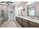 Elegant bathroom featuring double sinks, sleek cabinetry, and a glass enclosed shower at 28857 Picana Ln, Wesley Chapel, FL 33543