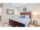 Well-lit bedroom featuring a dark wood bed frame and stylish decor at 28857 Picana Ln, Wesley Chapel, FL 33543