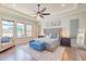 Serene main bedroom with tray ceiling, large windows, and a view of the water, creating a relaxing retreat at 28857 Picana Ln, Wesley Chapel, FL 33543