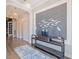 Elegant foyer with decorative wall art, stylish console table, and wood-look tile flooring at 28857 Picana Ln, Wesley Chapel, FL 33543