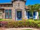 Charming front entrance with stone facade, blue door, and landscaped garden at 28857 Picana Ln, Wesley Chapel, FL 33543
