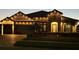 Beautiful stone home illuminated with warm string lights and a brick driveway at night at 28857 Picana Ln, Wesley Chapel, FL 33543