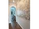 Elegant hallway featuring brick accent wall, wainscoting, hardwood floors, and arched entryway at 28857 Picana Ln, Wesley Chapel, FL 33543