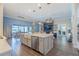 Open concept kitchen with large island, stainless appliances, and adjacent dining area with views of the outdoor living space at 28857 Picana Ln, Wesley Chapel, FL 33543