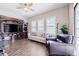 Comfortable living room with an entertainment center, three windows, wood-look flooring, and comfortable furniture at 28857 Picana Ln, Wesley Chapel, FL 33543