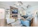Spacious living room with a fireplace feature wall, ceiling fans, and modern decor at 28857 Picana Ln, Wesley Chapel, FL 33543