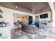 Relaxing covered patio with outdoor kitchen, comfortable seating, and an open view of the kitchen at 28857 Picana Ln, Wesley Chapel, FL 33543