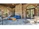 Inviting outdoor seating area featuring comfortable furniture, a wooden coffee table, and stone arches at 28857 Picana Ln, Wesley Chapel, FL 33543