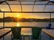 Breathtaking sunset view from the screened lanai with pool overlooking the tranquil lake, creating a serene backyard oasis at 28857 Picana Ln, Wesley Chapel, FL 33543
