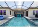 Backyard swimming pool featuring a covered enclosure, sun chairs, and lake views at 28857 Picana Ln, Wesley Chapel, FL 33543