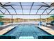 Stunning swimming pool with lake views, lounge chairs, and a covered enclosure at 28857 Picana Ln, Wesley Chapel, FL 33543