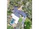 Expansive aerial view of home featuring a screened pool, dark roof, long driveway, and mature trees at 2947 Cedar Trce, Tarpon Springs, FL 34688
