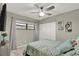 This bedroom features a ceiling fan, a window to let in natural light, and closet space at 2947 Cedar Trce, Tarpon Springs, FL 34688
