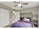 Comfortable bedroom featuring a tufted headboard, a side table with lamp, and ample closet space at 2947 Cedar Trce, Tarpon Springs, FL 34688