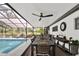This spacious outdoor dining area has seating for many people, a ceiling fan, and pool access at 2947 Cedar Trce, Tarpon Springs, FL 34688
