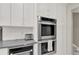 Modern kitchen with stainless steel double ovens, white cabinets, and sleek countertops at 2947 Cedar Trce, Tarpon Springs, FL 34688
