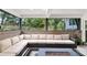 This covered patio has outdoor furniture and is surrounded by windows looking out onto a yard at 2947 Cedar Trce, Tarpon Springs, FL 34688