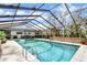 Inviting pool area under a screened enclosure, surrounded by ample patio space for lounging and entertaining at 2947 Cedar Trce, Tarpon Springs, FL 34688