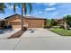Charming single-story home with a well-manicured lawn, mature palm trees, and a three-car garage at 329 Seneca Falls Dr, Apollo Beach, FL 33572