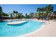 Resort-style pool with beach entry, palm trees and blue umbrellas for relaxing at 329 Seneca Falls Dr, Apollo Beach, FL 33572