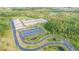 An aerial shot of the school building with a parking lot, roads, and some small ponds at 33228 Kateland Dr, Wesley Chapel, FL 33545