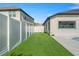 Green backyard area featuring artificial grass and a white fence creating a clean look and easy maintenance at 33228 Kateland Dr, Wesley Chapel, FL 33545