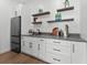 A modern bar area with white cabinets, sleek hardware, and a beverage refrigerator at 33228 Kateland Dr, Wesley Chapel, FL 33545