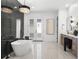 Elegant bathroom with marble wall, chandelier, soaking tub and double vanity at 33228 Kateland Dr, Wesley Chapel, FL 33545