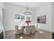 This dining room features a large window, wood floors, modern art, and a round dining table at 33228 Kateland Dr, Wesley Chapel, FL 33545