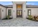 Home with a tile driveway, trimmed grass, and double door entrance at 33228 Kateland Dr, Wesley Chapel, FL 33545