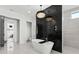 Spa-like bathroom with a freestanding tub, walk-in shower, and sleek black marble accent wall at 33228 Kateland Dr, Wesley Chapel, FL 33545