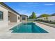 Relaxing backyard oasis featuring a sparkling pool and spa with elegant travertine tile at 33228 Kateland Dr, Wesley Chapel, FL 33545