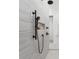 Shower with sleek black fixtures, marble walls, and a convenient recessed shelf at 33228 Kateland Dr, Wesley Chapel, FL 33545